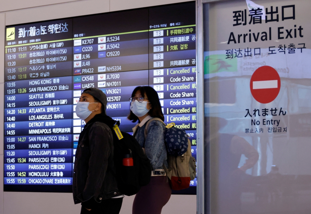Foreign travellers walk upon their arrival at the Haneda International Airport, on the first day Japan opened its doors to tourists after closing them for two-and-a-half years due to travel restrictions sparked by the outbreak of the coronavirus disease (COVID-19) pandemic, in Tokyo, Japan October 11, 2022. REUTERS/Issei Kato