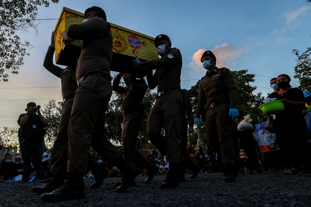Police officers carry the casket of a victim on the day of a cremation at Wat Rat Samakee temple, following a mass shooting at a day care centre, in the town of Uthai Sawan, in the province of Nong Bua Lam Phu, Thailand, on October 11, 2022. REUTERS/Athit Perawongmetha