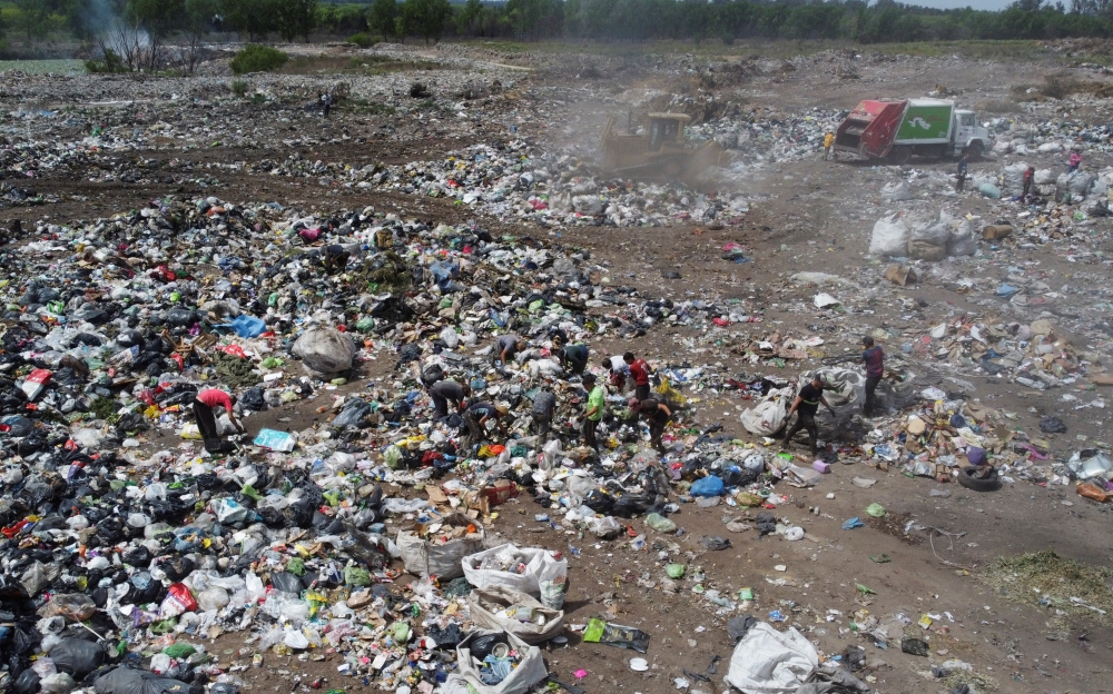 Waste recyclers look through heaps of waste unloaded from a garbage truck at a landfill for cardboard, plastic and metal, which they sell while working 12-hour shifts, as Argentina faces one of the world's highest inflation rates, set to top 100% this year, in Lujan, on the outskirts of Buenos Aires, Argentina October 5, 2022. REUTERS/Miguel Lo Bianco
