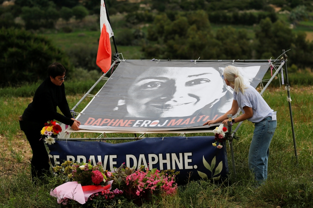 Activists unveil a banner of anti-corruption journalist Daphne Caruana Galizia that reads 