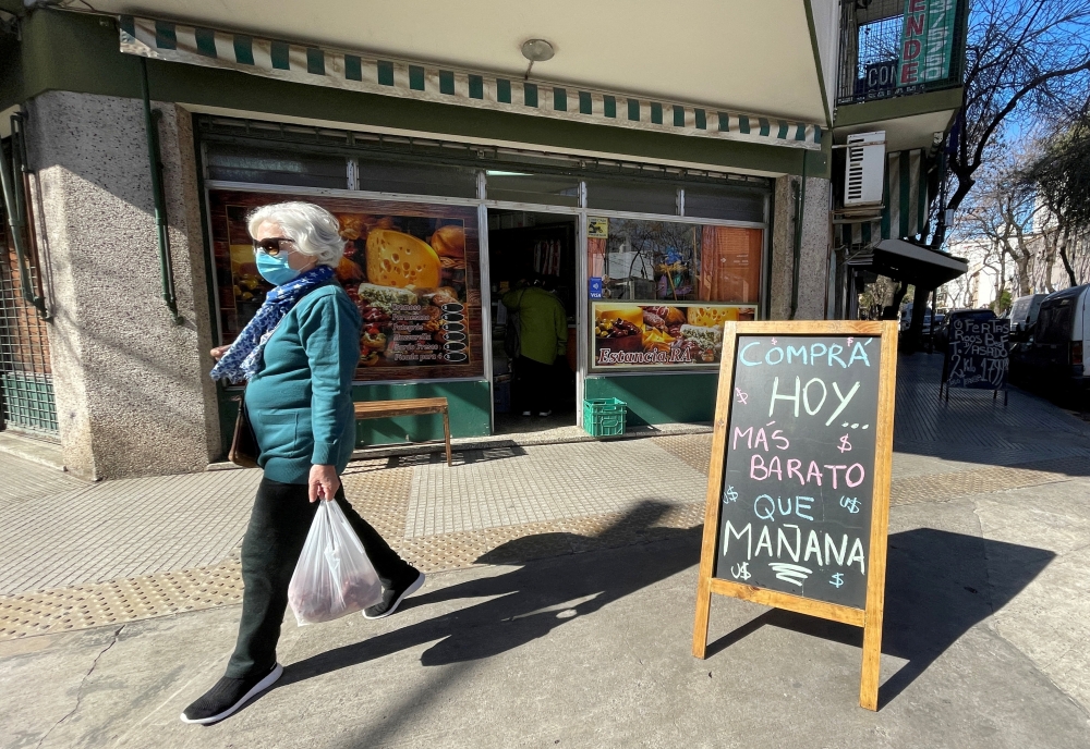 A shopper walks past a placard that reads 