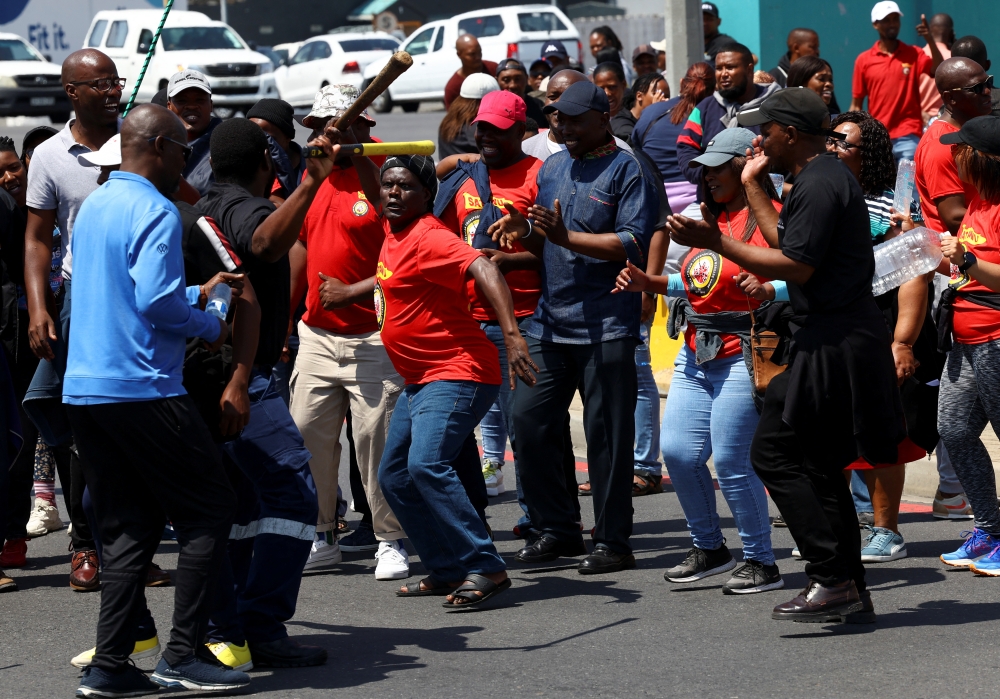 Workers at South Africa's state-owned logistics firm Transnet demonstrate for a second week outside the Port of Cape Town as they continue on a nationwide strike action that could paralyse ports and freight rail services in Cape Town, South Africa, October 17, 2022. (REUTERS/Esa Alexander)