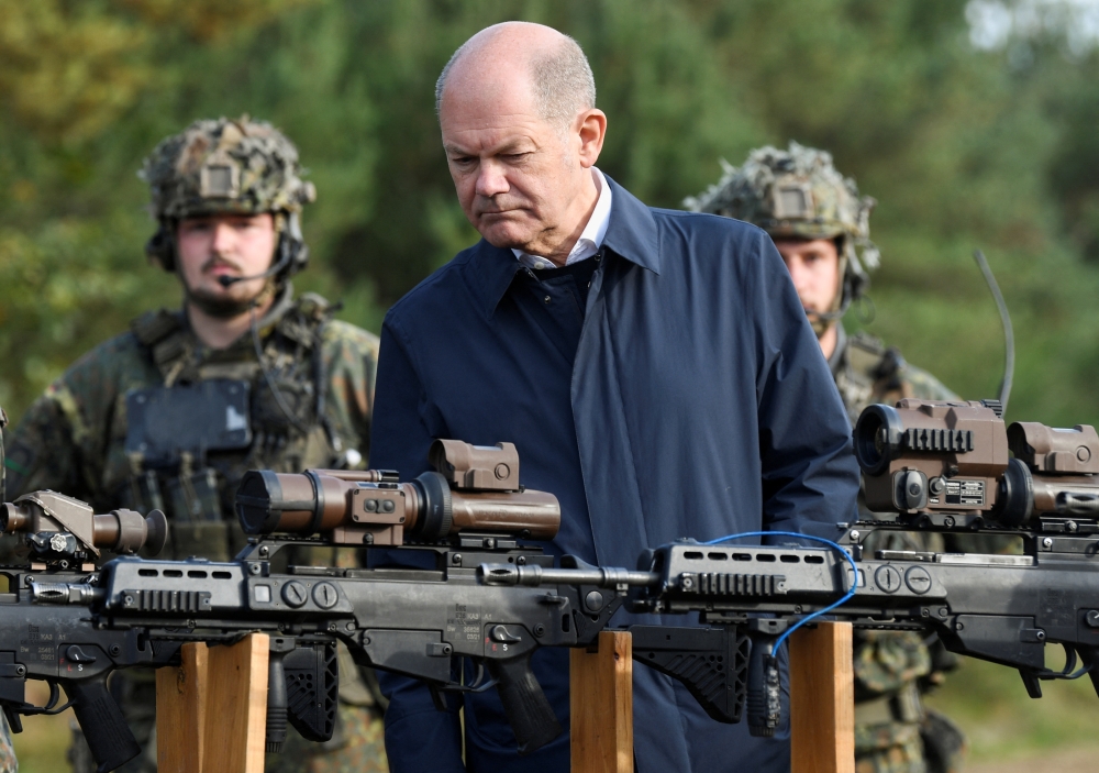 German Chancellor Olaf Scholz looks at weapons during a visit to a military base of the German army Bundeswehr in Bergen, Germany, on October 17, 2022. REUTERS/Fabian Bimmer