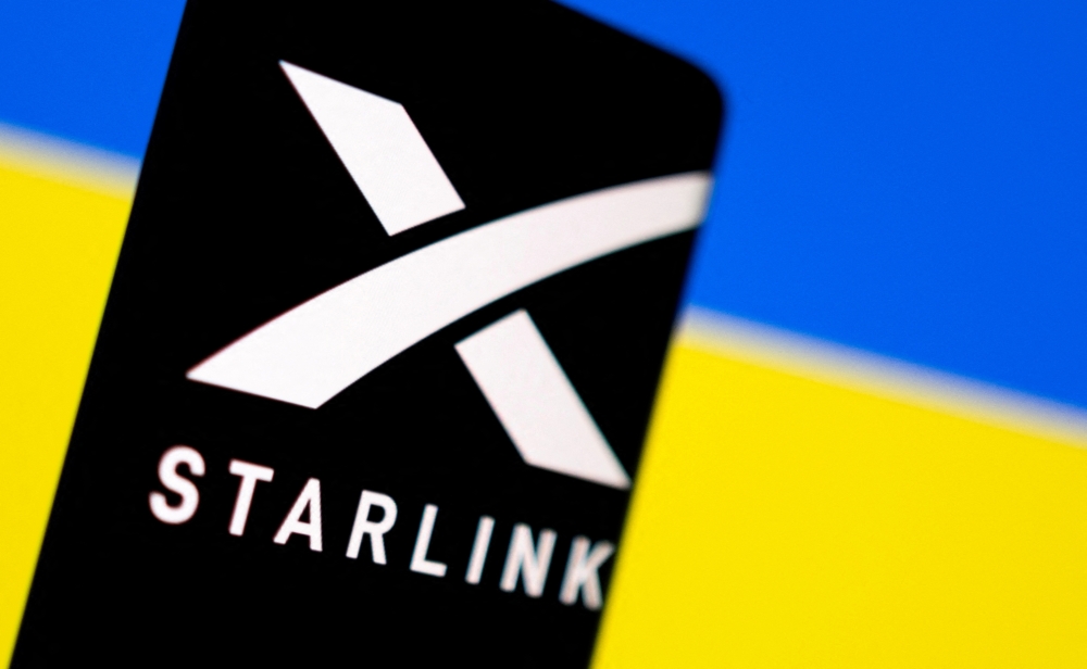 Starlink logo is seen on a smartphone in front of displayed Ukrainian flag in this illustration taken February 27, 2022. (REUTERS/Dado Ruvic)