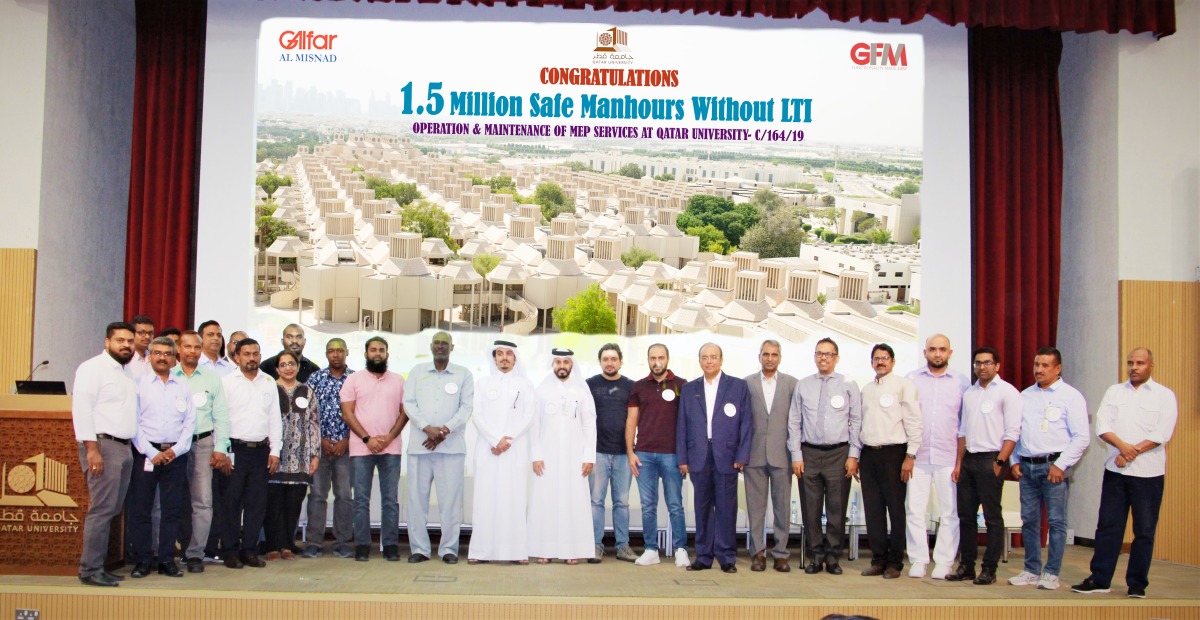 Officials pose for a group photo to celebrate the achievement of 1.5 Million Safe Man Hours without LTI for the Operations and Maintenance of MEP Services at Qatar University.