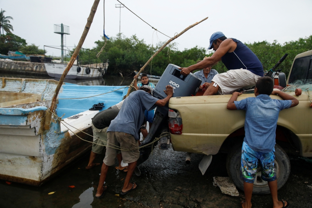 Fishermen upload an outboard motor to a pickup as Hurricane Roslyn approaches tourist zones along Mexico's Pacific coast, in San Blas in Nayarit state, Mexico, on October 22, 2022. REUTERS/Hugo Cervantes