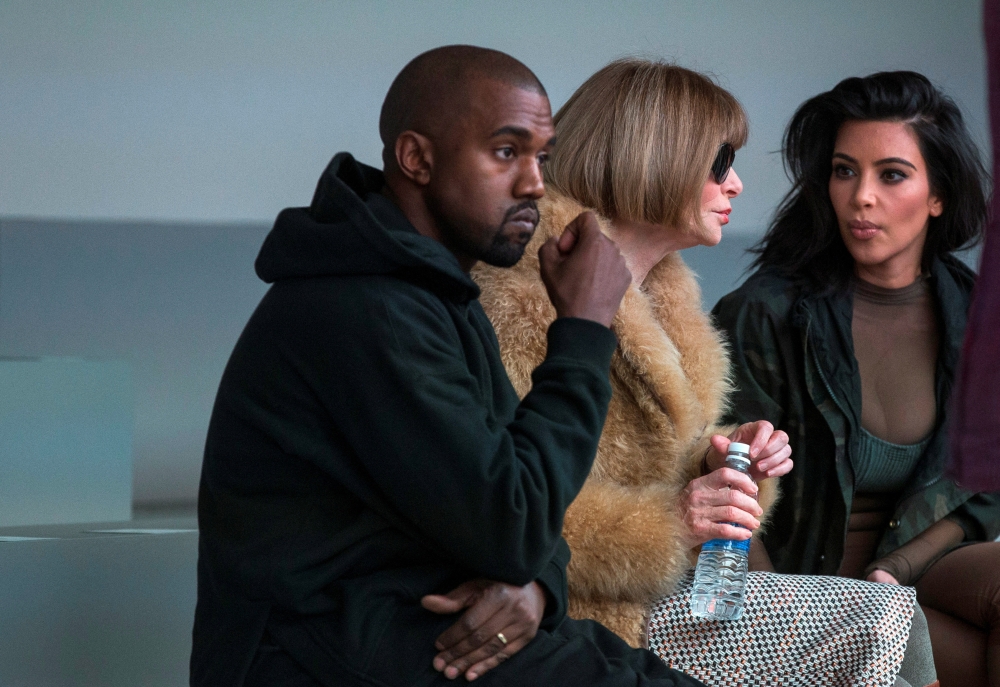 Singer Kanye West watches models rehearse while sitting with his wife Kim Kardashian (right) and Anna Wintour before presenting his Fall/Winter 2015 partnership with Adidas at New York Fashion Week on February 12, 2015. File Photo / Reuters