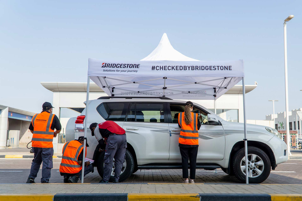Volunteers check the tyre of a car during the campaign.