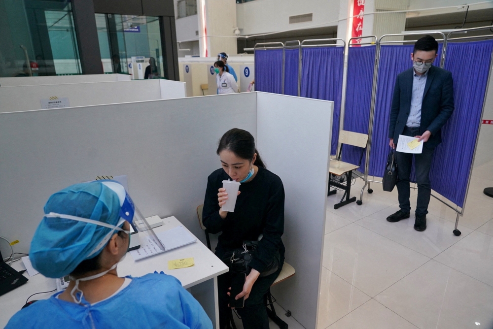 A resident takes an inhaled COVID-19 vaccine as a booster dose at a hospital in Shanghai, China October 26, 2022. China Daily via REUTERS/File Photo