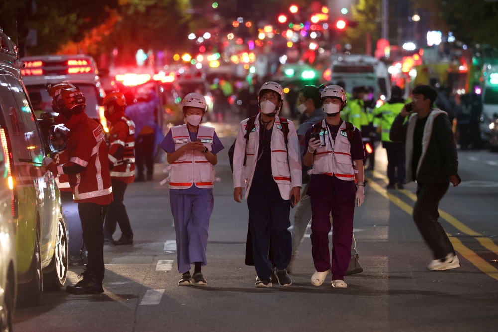 Rescue team and firefighters work at the scene where dozens of people were injured in a stampede during a Halloween festival in Seoul, South Korea, on October 30, 2022. REUTERS/Kim Hong-ji 