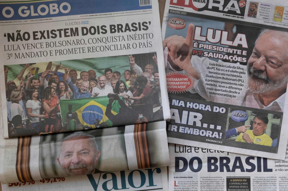 Picture of Brazilian newspapers taken in Rio de Janeiro, Brazil, on October 31, 2022, a day after Luiz Inacio Lula da Silva reclaimed the presidency in a run-off election. (Photo by Pablo PORCIUNCULA / AFP)