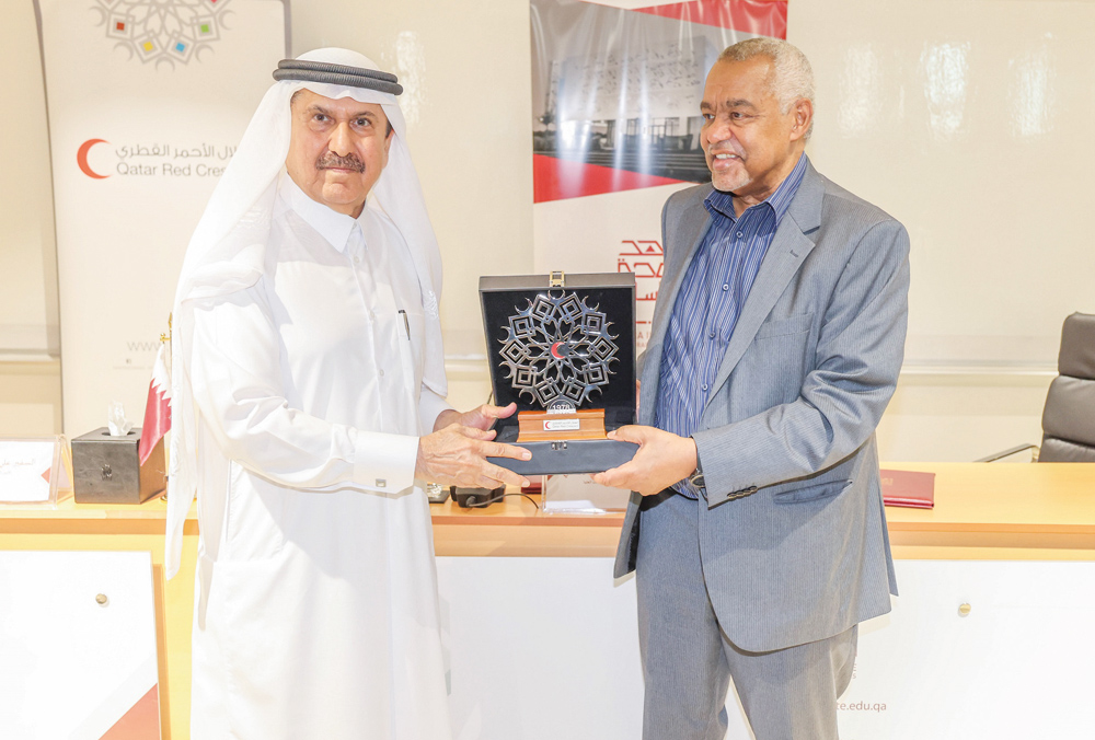 Dr. Abdel Wahab Al Affendi, President and Provost of Doha Institute, and Ali bin Hassan Al Hammadi, Secretary-General of QRCS, exchanging documents after signing the agreement yesterday.