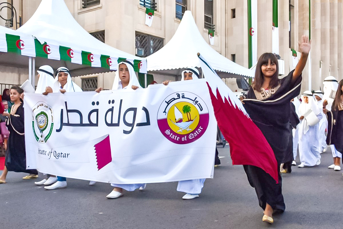 Children carry Algeria and Qatar flags during Algeria's 68th Anniversary of the Revolution day in Algiers on Tuesday. (QNA)