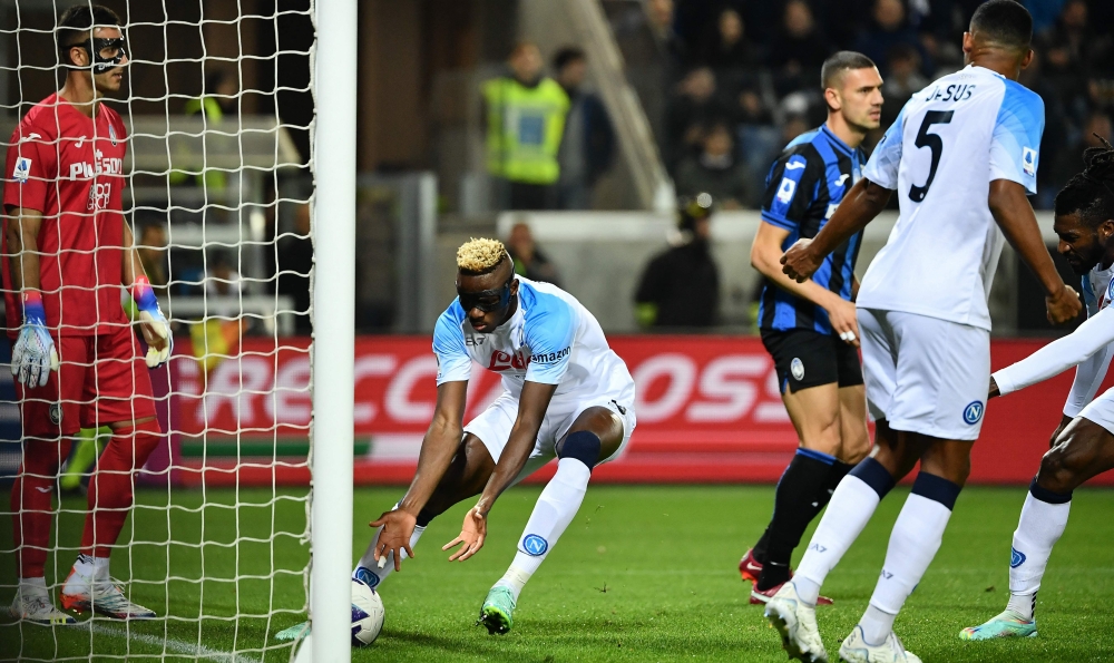 Napoli's Nigerian forward Victor Osimhen grabs the ball after scoring a header to equalize 1-1 during the Italian Serie A football match between Atalanta Bergamo and Napoli on November 5, 2022 at the Atleti Azzurri d'Italia stadium in Bergamo. (Photo by Isabella BONOTTO / AFP)