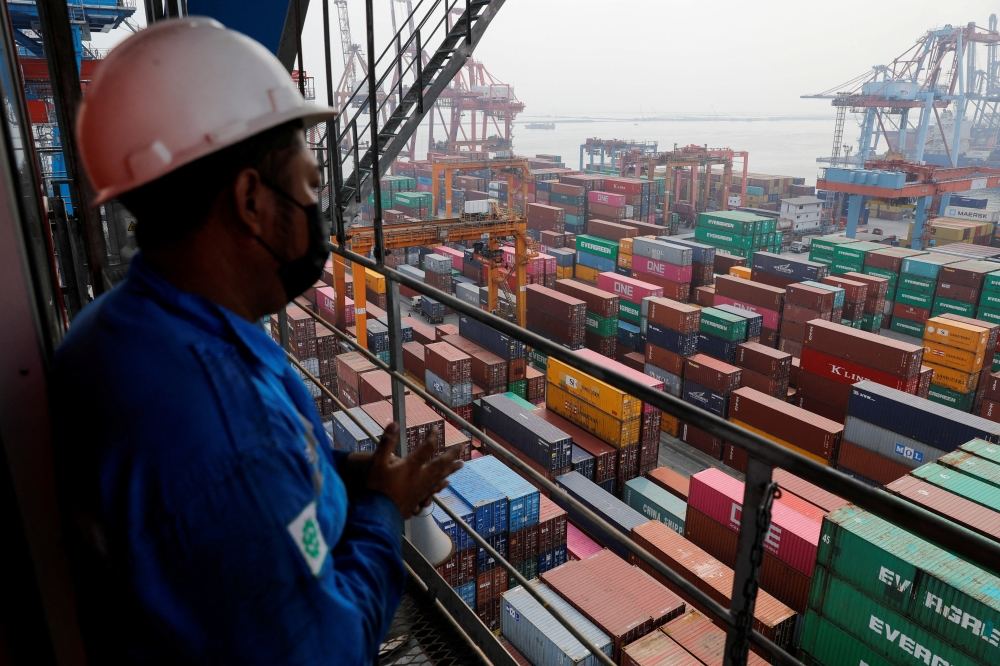 A technician stands on a crane at the Tanjung Priok port in Jakarta, Indonesia, August 3, 2022. REUTERS/Willy Kurniawan/File Photo