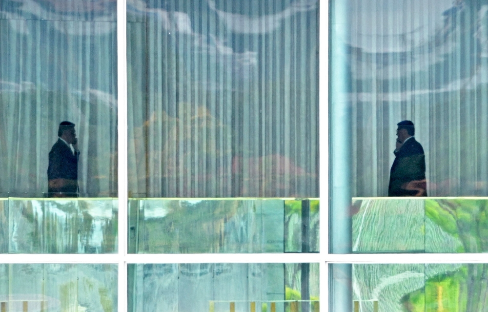 In this file photo taken on November 1, 2022, Brazilian President Jair Bolsonaro (right) walks at Alvorada Palace in Brasilia, before addressing the country for the first time since losing in the run-off election of October 30. (AFP/EVARISTO SA)
