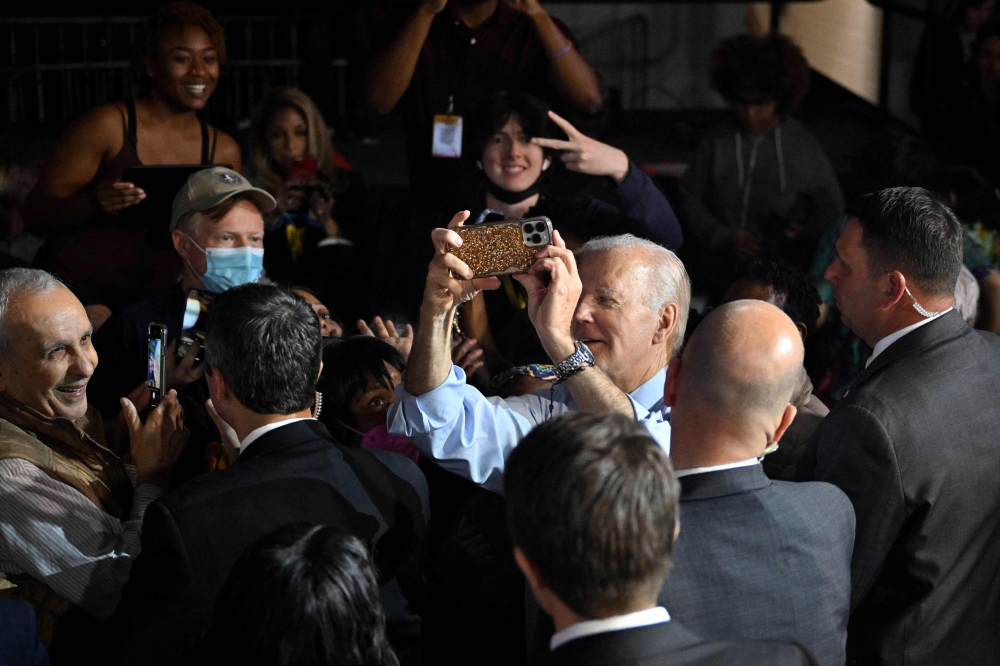 US President Joe Biden takes pictures with supporters during a rally on the eve of the US midterm elections, at Bowie State University in Bowie, Maryland, on November 7, 2022. (AFP/Mandel Ngan)
