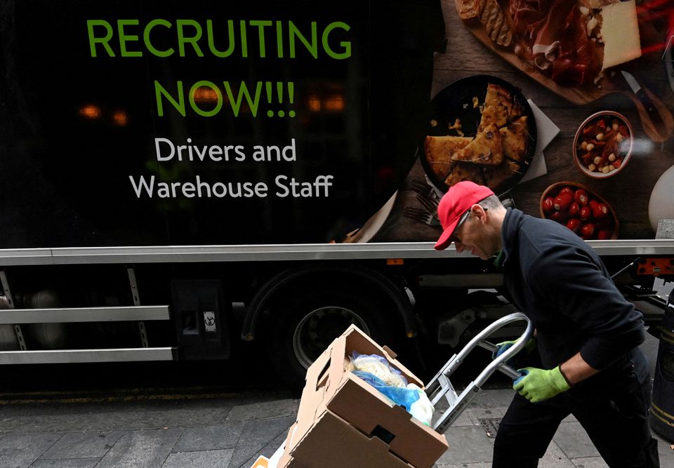 A lorry driver passes a sign on the side of his vehicle advertising for jobs as he makes a delivery, in London, Britain, on October 13, 2021. File Photo / Reuters