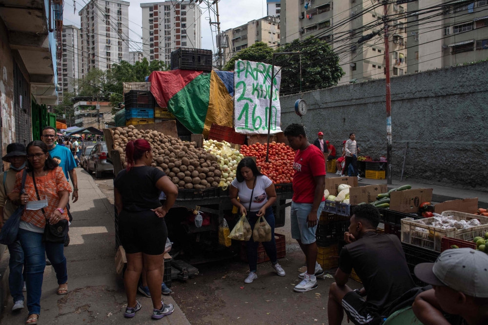 People buy vegetables in a street market at the Jose Felix Ribas community in the Petare neighborhood in Caracas, Venezuela, on November 5, 2022. (Photo by Federico PARRA / AFP)