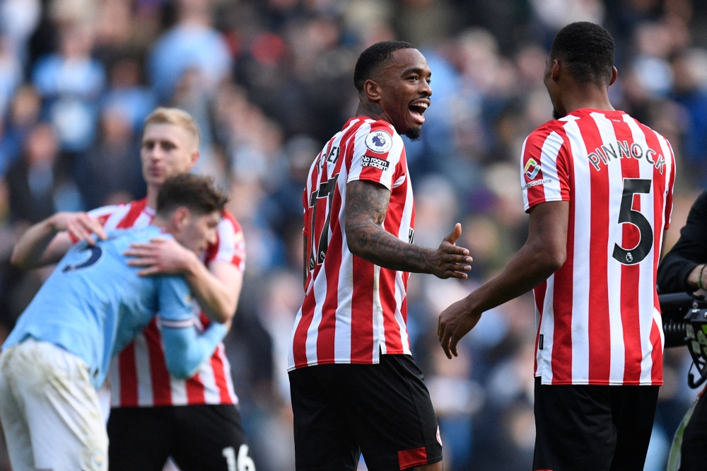 Brentford's English striker Ivan Toney (centre) celebrates with Brentford's English-born Jamaican defender Ethan Pinnock (right) on the pitch after the English Premier League football match between Manchester City and Brentford at the Etihad Stadium in Manchester, north west England, on November 12, 2022. - Brentford won the game 2-1. (Photo by Oli SCARFF / AFP) 