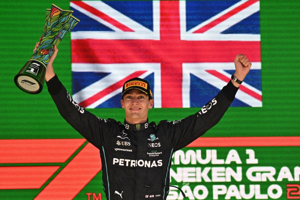 Mercedes' British driver George Russell celebrates in the podium after winning the Formula One Brazil Grand Prix, at the Autodromo Jose Carlos Pace racetrack, also known as Interlagos, in Sao Paulo, Brazil, on November 13, 2022. (Photo by NELSON ALMEIDA / AFP)