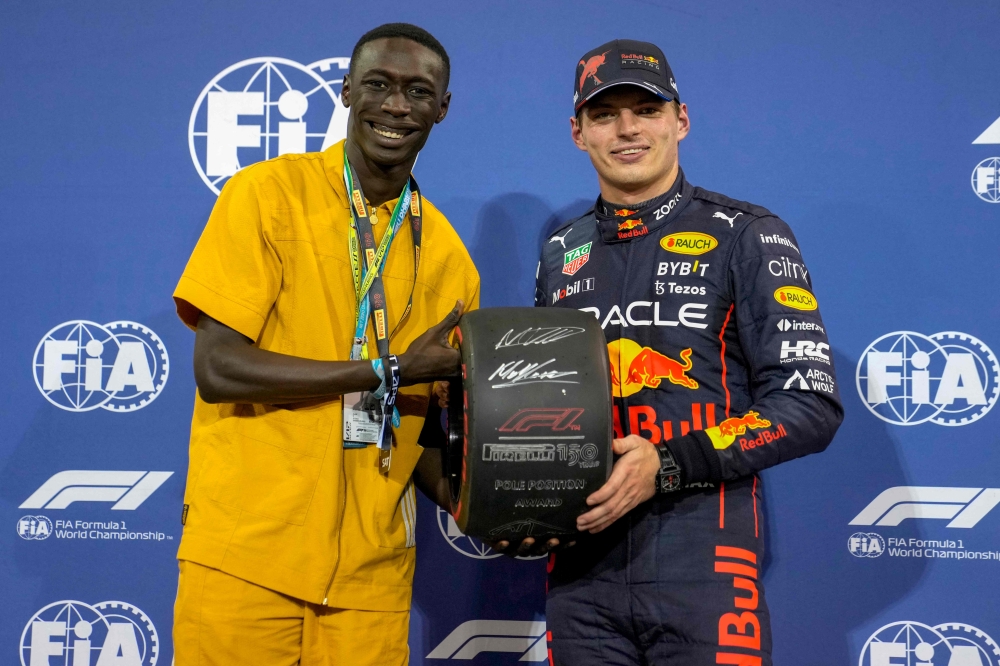 Red Bull's Dutch driver Max Verstappen (right) receives the Pole Position Award after the qualifying session on the eve of the Abu Dhabi Formula One Grand Prix at the Yas Marina Circuit in the Emirati city of Abu Dhabi on November 19, 2022. (Photo by Kamran JEBREILI / POOL / AFP)