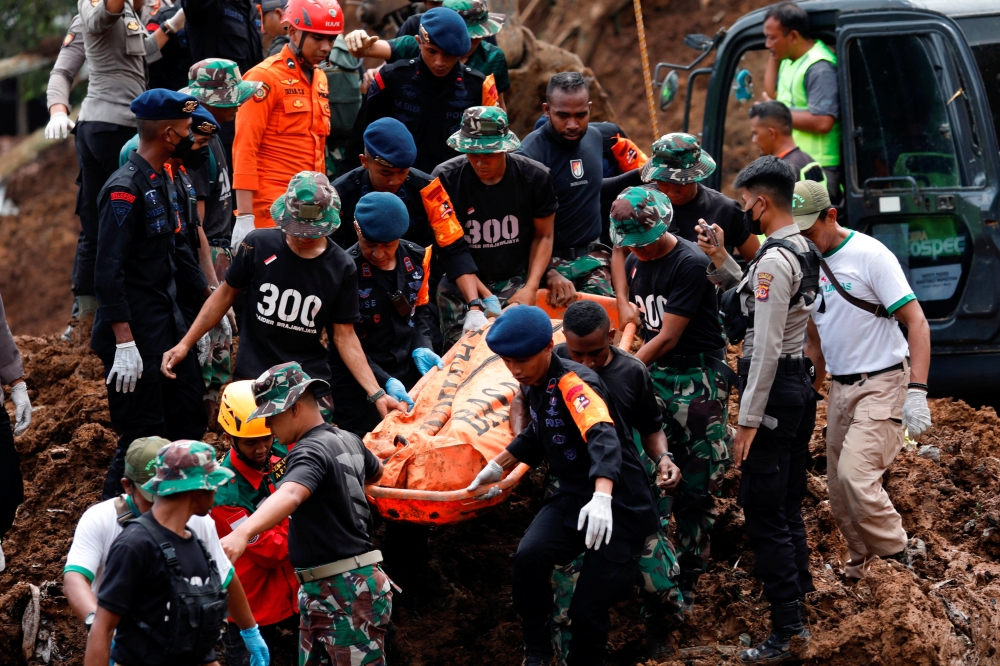 Indonesia rescue members carry a victims body from the site of a landslide caused by the earthquake in Cugenang, Cianjur, West Java province, Indonesia, November 22, 2022. REUTERS/Ajeng Dinar Ulfiana