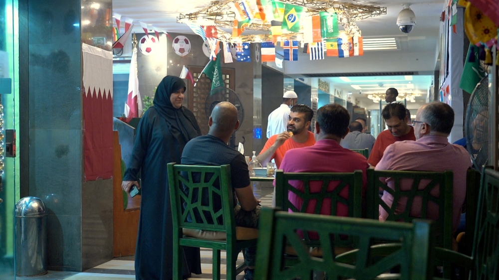 Shams al-Qassabi, the owner of the Shay al-Shamous restaurant, talks with a group of United States football supporters, in Doha, Qatar, November 23, 2022. (REUTERS/Will Russell)