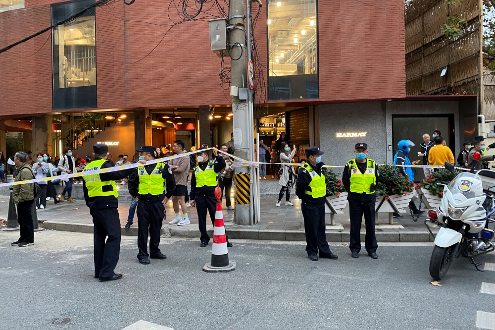 Police officers stand next to a cordon line set up near the site where a protest against COVID-19 curbs took place. Reuters/David Stanway