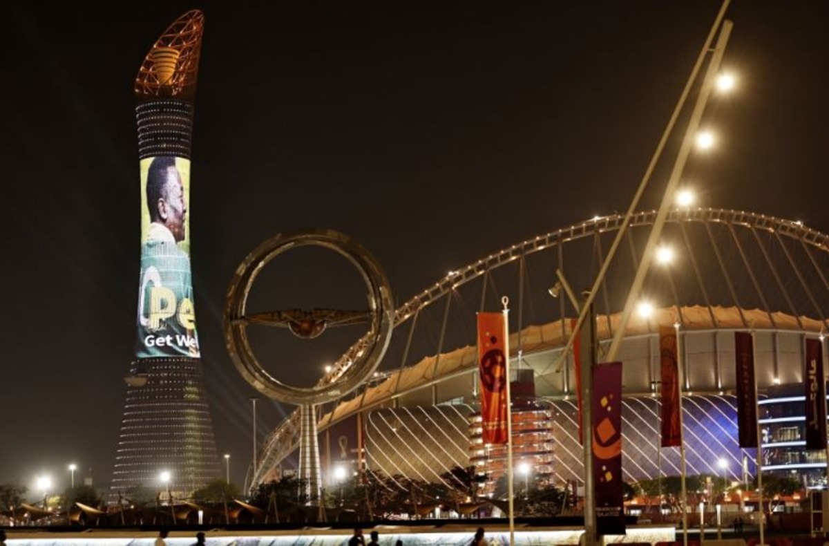 A picture taken on December 3, 2022, in Doha, during the Qatar 2022 World Cup football tournament, shows the Torch tower of Doha also known as the Aspire Tower, lit by a screen depicting Brazilian star Pele and reading a message in support to the former Brazilian football player who is being treated for a