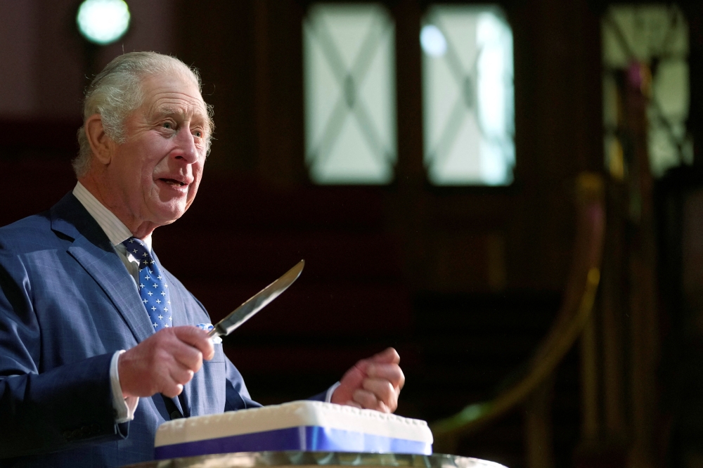 Britain's King Charles III cuts a cake to celebrate the 40th anniversary of Business in the Community (BITC), at the Central Hall Westminster in London, Britain, December 7, 2022. (Kin Cheung/Pool via REUTERS)