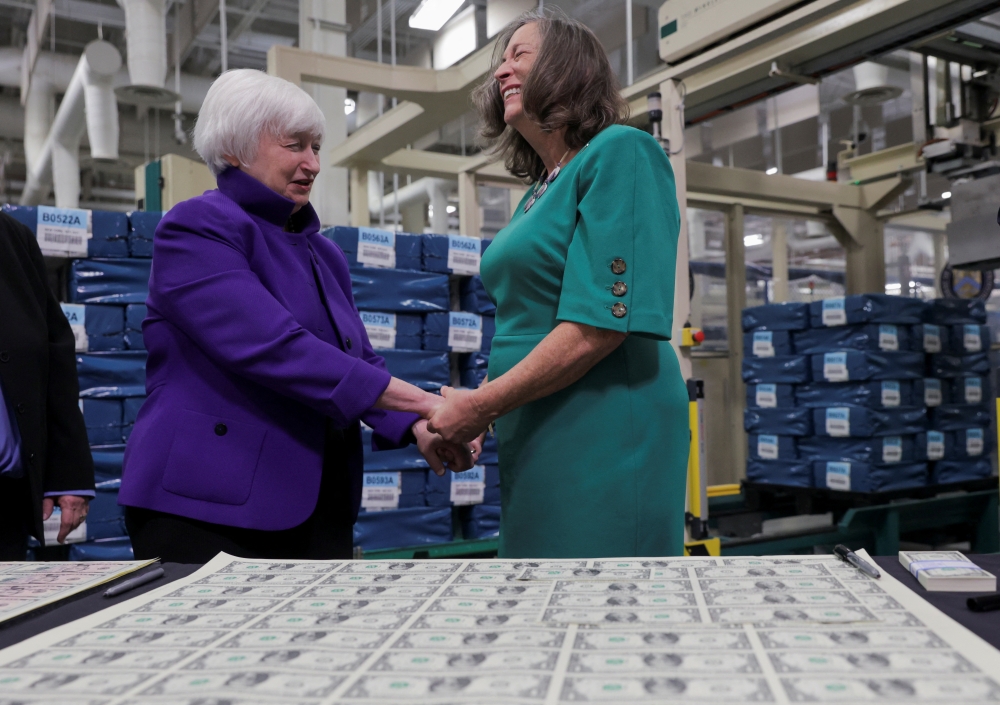US Treasury Secretary Janet Yellen holds the hands of US Treasury Chief Lynn Malerba as she presides over the unveiling of the first US banknotes printed with two women's signatures at an event in Fort Worth, Texas, US, December 8, 2022. (REUTERS/Shelby Tauber)