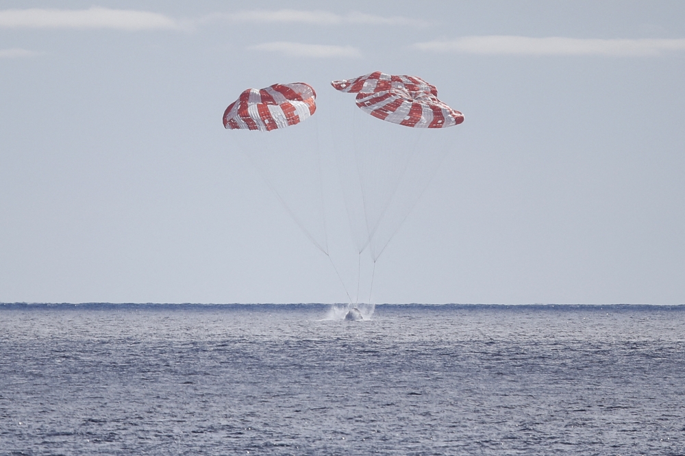 NASA's unmanned Orion spaceship splashes down in the Pacific Ocean off Baja California, Mexico, on December 11, 2022. - Orion was launched November 16 on the Artemis rocket for a 25-day mission to the Moon. The main goal of this mission was to test Orion's heat shield -- for the day when it is humans and not test mannequins riding inside. (Photo by CAROLINE BREHMAN / POOL / AFP)