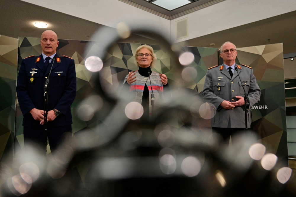 German Defence Minister Christine Lambrecht (centre) is flanked by Eberhard Zorn (right), Inspector General of the German Armed Forces Bundeswehr, and Ingo Gerhartz, Inspector of the Air Force, as she gives a press conference on December 14, 2022 in Berlin. (Photo by John MacDougall / AFP)