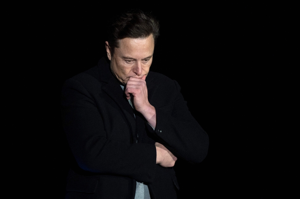In this file photo taken on February 10, 2022 Elon Musk pauses and looks down as he speaks during a press conference at SpaceX's Starbase facility near Boca Chica Village in South Texas. - A Twitter account that tracked flights of Elon Musk's private jet was grounded on December 14, 2022 despite the billionaire's talk of free speech. (Photo by JIM WATSON / AFP)