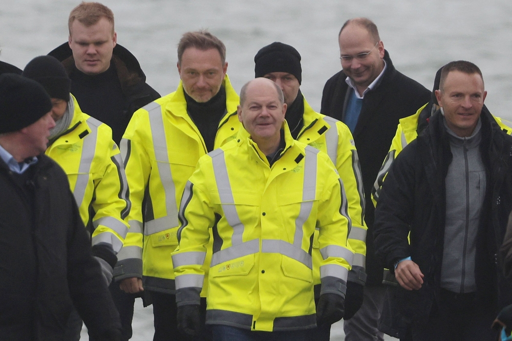 German Chancellor Olaf Scholz (centre), German Finance Minister Christian Lindner (fourth left) and German Minister of Economics and Climate Protection Robert Habeck (behind Scholz, right) arrive for the opening ceremony of the Uniper Liquefied Natural Gas (LNG) terminal at the Jade Bight in Wilhelmshaven, northern Germany on December 17, 2022. (Photo by FOCKE STRANGMANN / AFP)
 