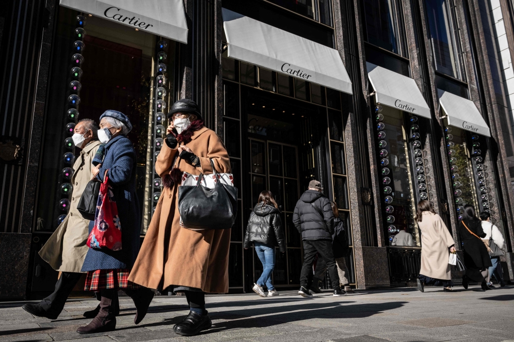 People walk through Ginza area in Tokyo on December 20, 2022. (Photo by Yuichi Yamazaki / AFP)
 