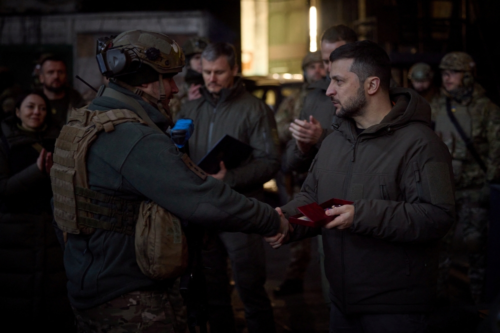 Ukraine's President Volodymyr Zelenskiy awards a Ukrainian service member at a position in the frontline town of Bakhmut in Donetsk region, Ukraine December 20, 2022. Ukrainian Presidential Press Service/Handout via Reuters