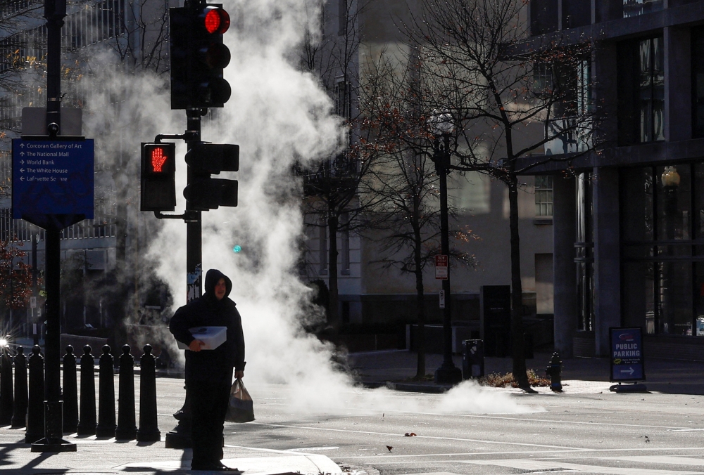 Pedestrians walk in the cold near the White House, as temperatures drop throughout the day as part of a large winter weather system across the country, in Washington on December 23, 2022. REUTERS/Jonathan Ernst