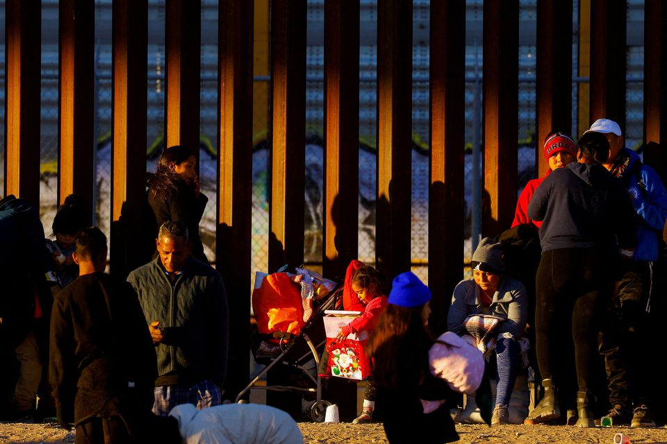 A migrant girl holds a Christmas present, as she queues with her family near the border wall to request asylum in El Paso, Texas, US, seen from Ciudad Juarez, Mexico, on December 25, 2022. REUTERS/Jose Luis Gonzalez
