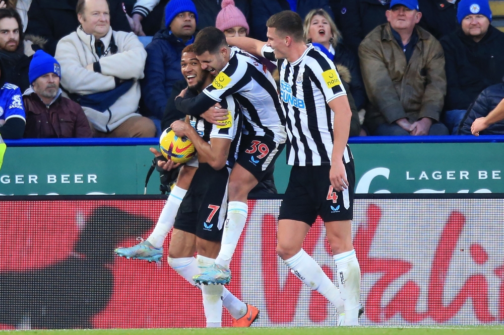 Newcastle United's striker Joelinton (left) celebrates with Bruno Guimaraes (centre) and Sven Botman after scoring their third goal during the English Premier League match against Leicester City at King Power Stadium in Leicester, central England on December 26, 2022. (Photo by Lindsey Parnaby / AFP) 