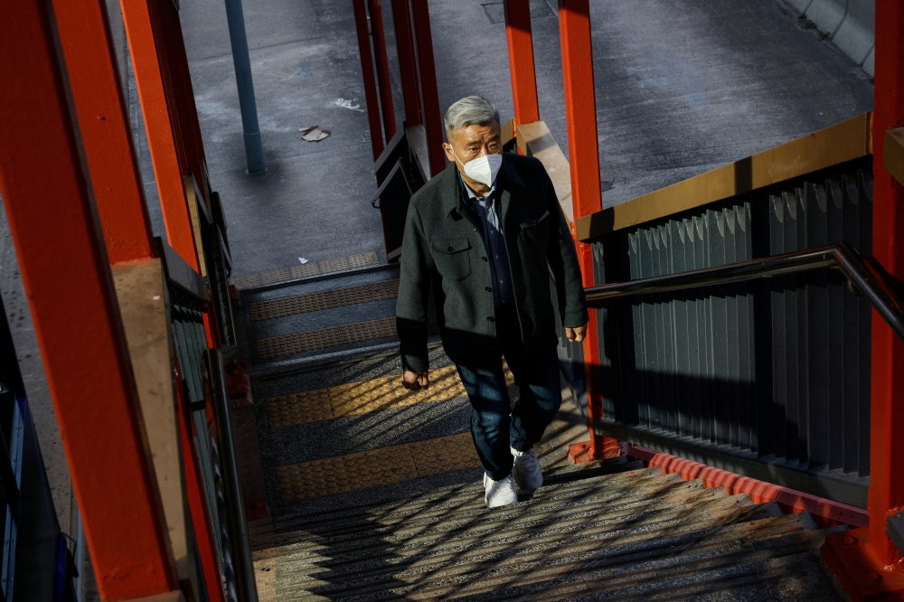 A man wearing a face mask walks on the street during the coronavirus disease (COVID-19) pandemic in Hong Kong, China, December 28, 2022. REUTERS/Tyrone Siu