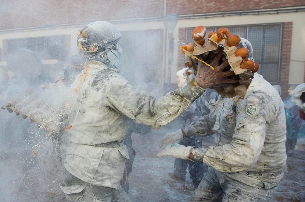 Revellers dressed in mock military garb take part in 'Els Enfarinats' food-battle in the southeastern Spanish town of Ibi on December 28, 2022. (Photo by Jaime Reina / AFP)