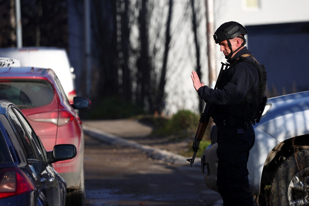 A Kosovo police officer patrols in the northern part of the ethnically-divided town of Mitrovica, Kosovo, December 28, 2022. REUTERS/Florion Goga