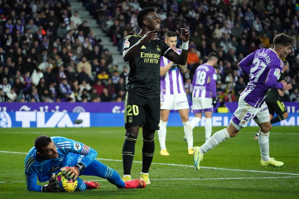 Real Madrid's Brazilian forward Vinicius Junior (centre) reacts as Real Valladolid's Spanish goalkeeper Jordi Masip holds the ball during the Spanish League football match between Real Valladolid FC and Real Madrid CF at the Jose Zorilla stadium in Valladolid on December 30, 2022. (Photo by CESAR MANSO / AFP)