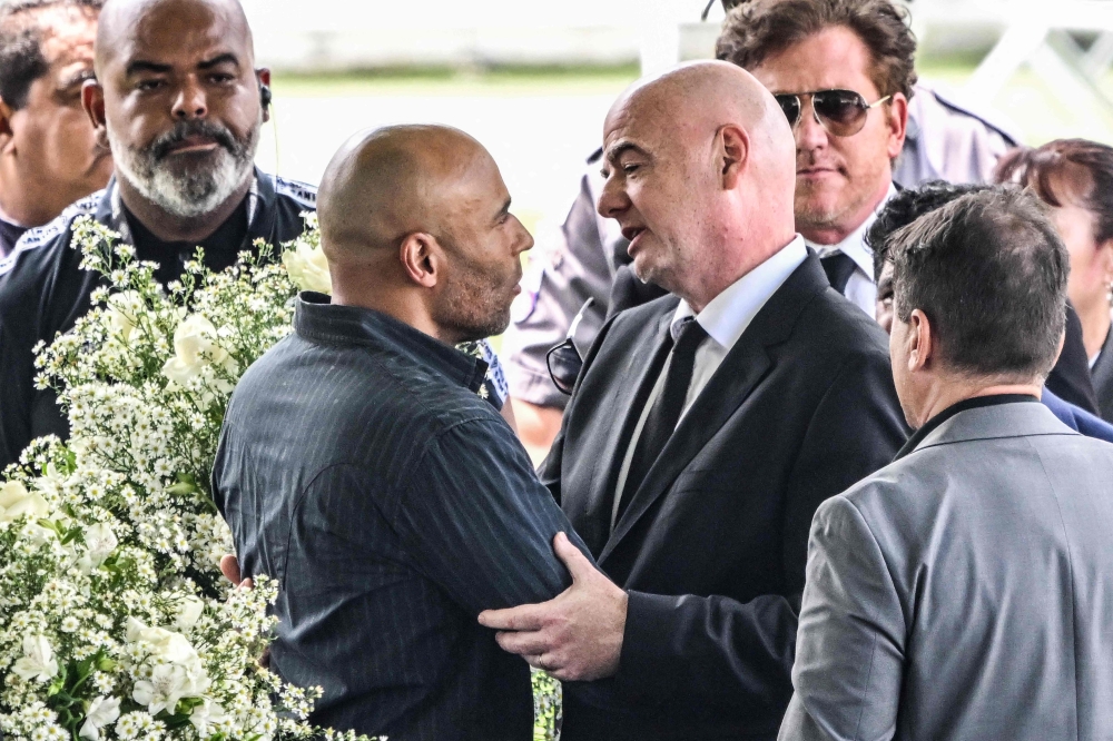 FIFA President Gianni Infantino greets the son of Brazilian football legend Pele, Edinho, during his wake at the Urbano Caldeira stadium in Santos, Sao Paulo, Brazil on January 2, 2023. (Photo by NELSON ALMEIDA / AFP)