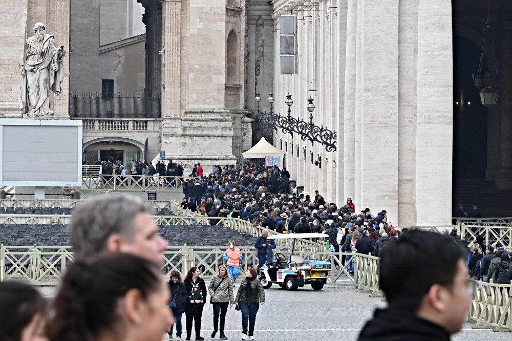People wait in line to pay respect at the body of Pope Emeritus Benedict XVI laying in state in the St. Peter's basilica in the Vatican, on January 2, 2023. (Photo by Andreas Solaro / AFP)