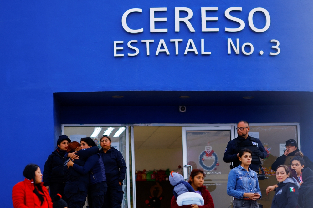 A woman hugs a woman from the Penitentiary Security Police at the Cereso number 3 state prison after unknown assailants entered the prison and freed several inmates, resulting in injuries and deaths, according to local media, in Ciudad Juarez, Mexico January 1, 2023. REUTERS/Jose Luis Gonzalez