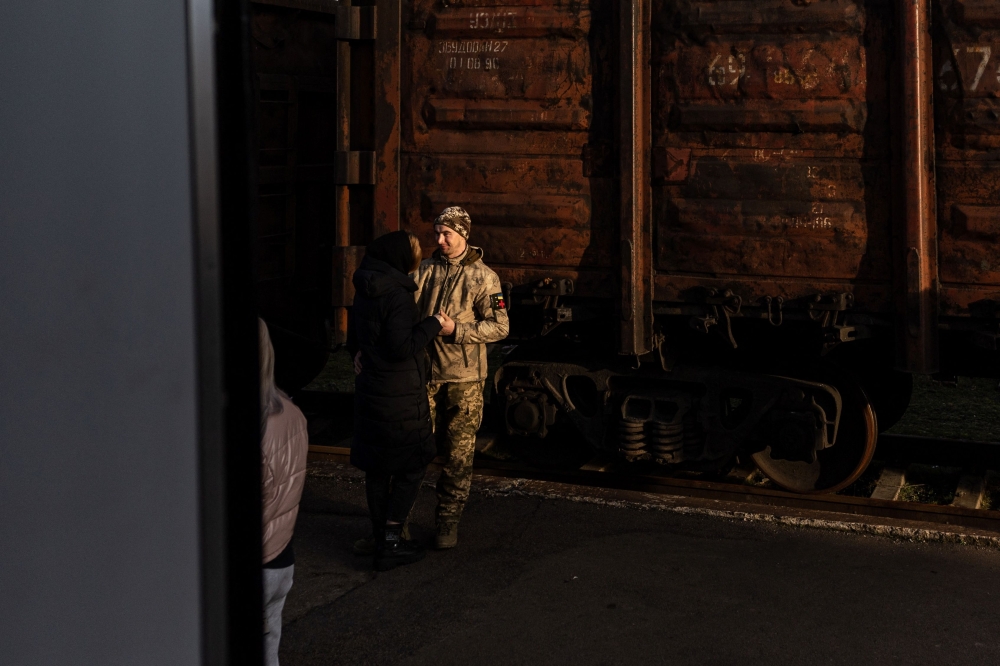 A Ukrainian serviceman bids farewell to his partner at Kramatorsk train station in eastern Ukraine on January 3, 2022, amid Russian invasion of Ukraine. (Photo by Sameer Al-DOUMY / AFP)