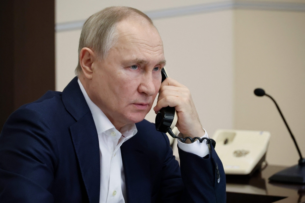 Russian President Vladimir Putin talks on the phone with Agatha Bylkova, an eight-year-old girl from the Kurgan region who took part in the New Year Tree of Wishes nationwide charity campaign, in Moscow on January 3, 2023. (Photo by MIKHAIL KLIMENTYEV / SPUTNIK / AFP)